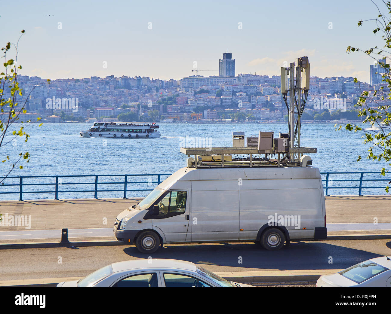 Un furgone con la rete di comunicazioni mobili antenne parcheggiato di fronte al Bosforo con lo skyline di Istanbul in background. La Turchia. Foto Stock