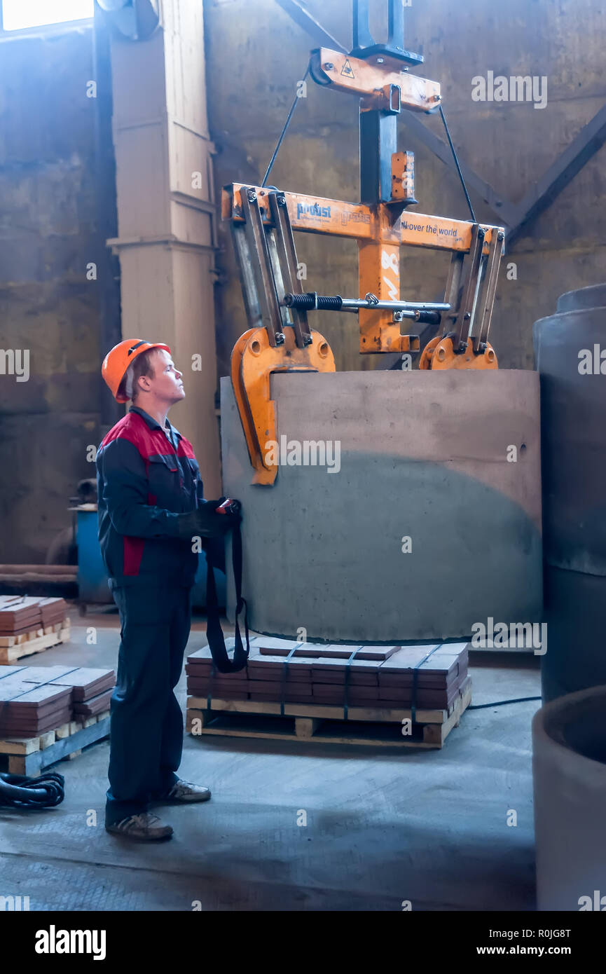 Tyumen, Russia - Agosto 13, 2013: Circle pit rendendo dipartimento al materiale di costruzione fabbrica ZHBI-5 (merci concrete impianto n. 5). Lavoratore si muove prep Foto Stock