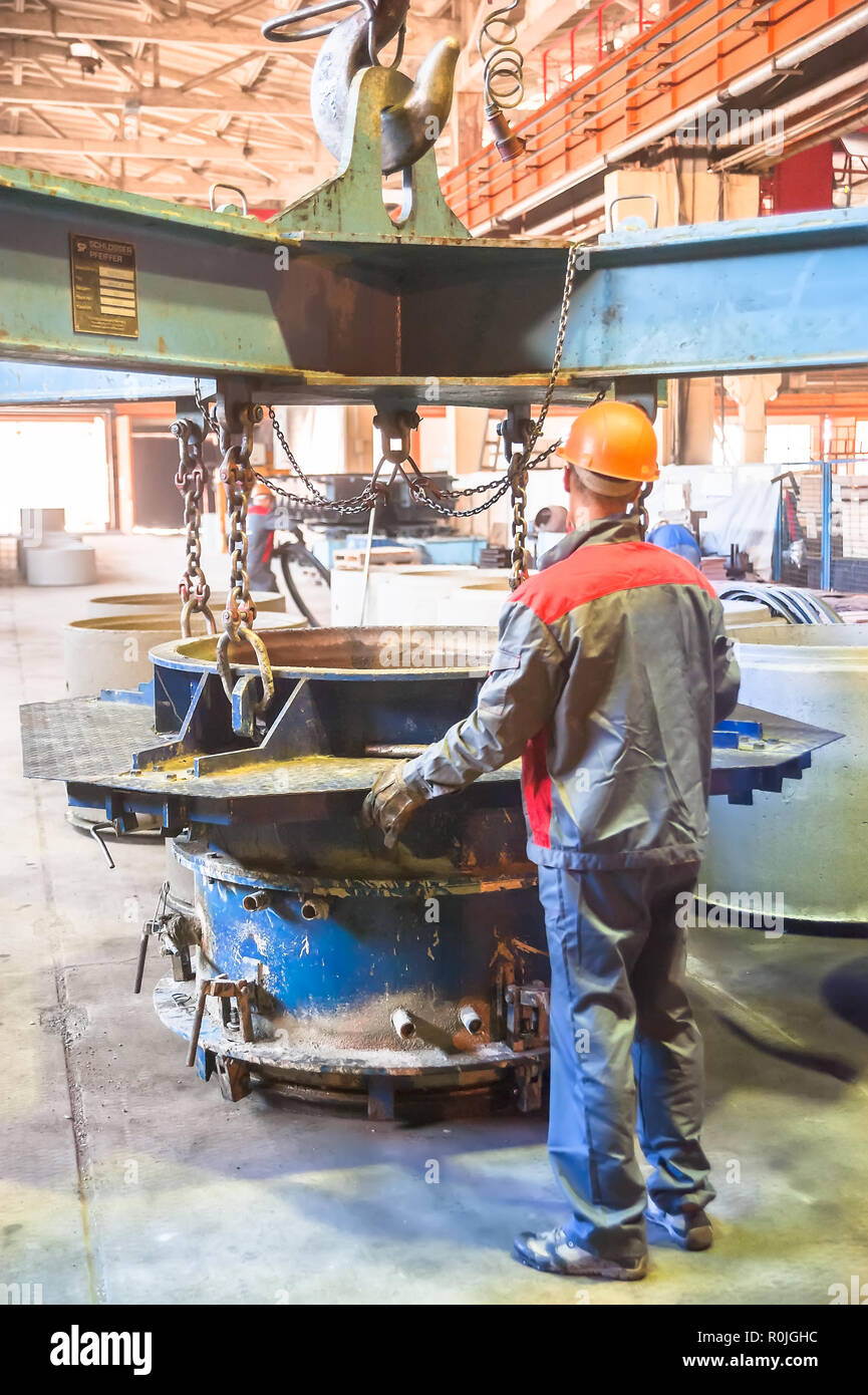 Tyumen, Russia - Agosto 13, 2013: Circle pit rendendo dipartimento al materiale di costruzione fabbrica ZHBI-5 (merci concrete impianto n. 5). Lavoratore trasporta Foto Stock