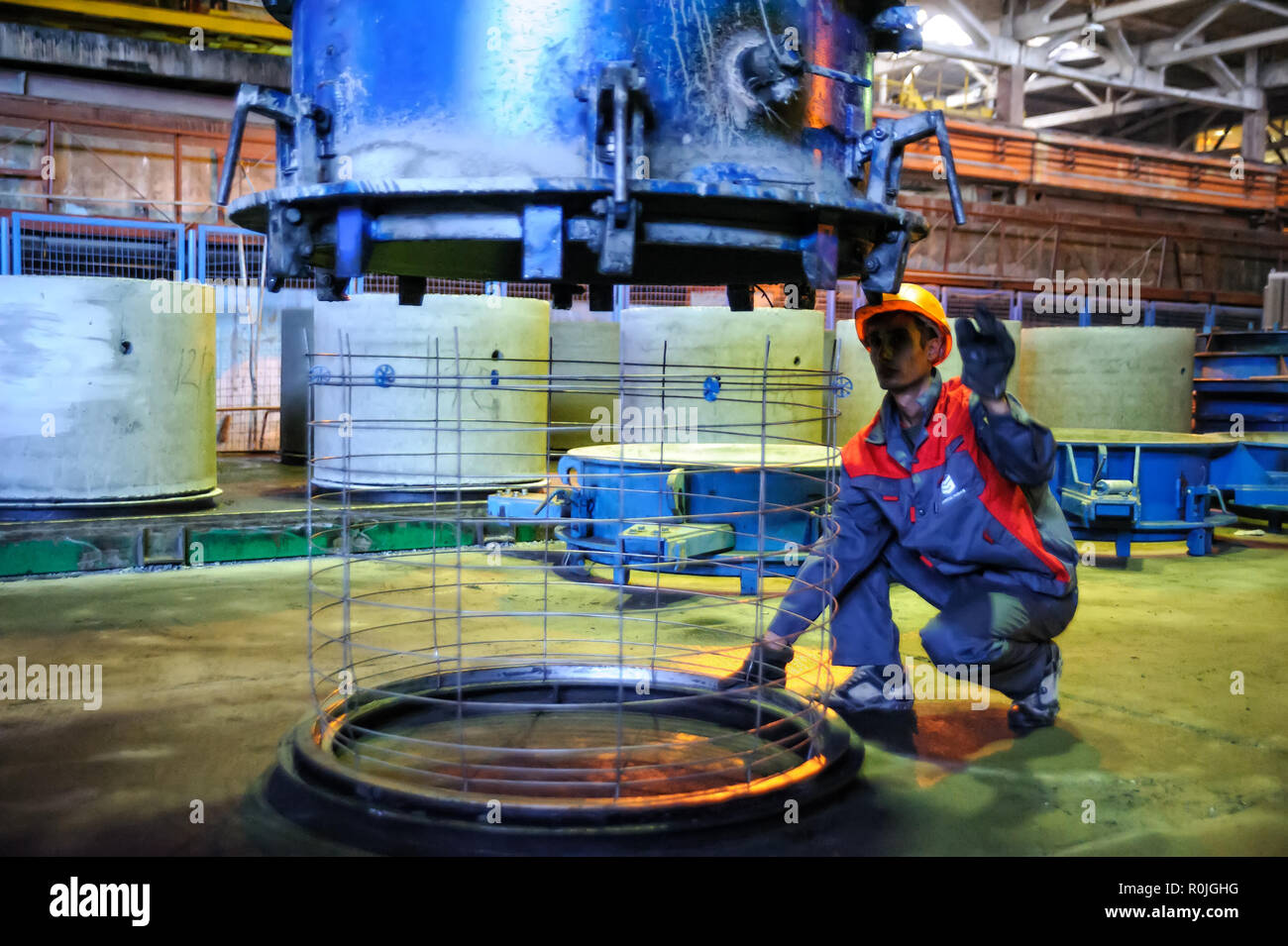 Tyumen, Russia - Agosto 13, 2013: Circle pit rendendo dipartimento al materiale di costruzione fabbrica ZHBI-5. Merci concrete impianto n. 5. Controlli del lavoratore pr Foto Stock