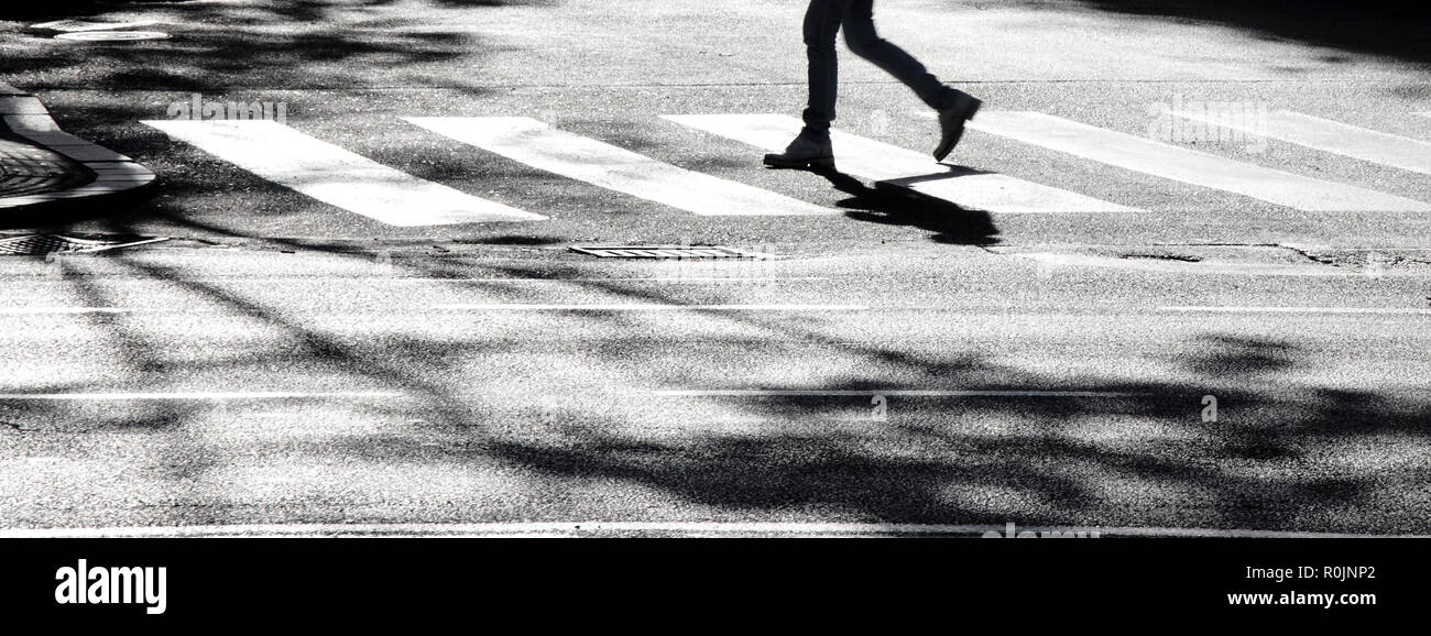 Sfocata ombra silhouette di un attraversamento pedonale via della città, in bianco e nero Foto Stock