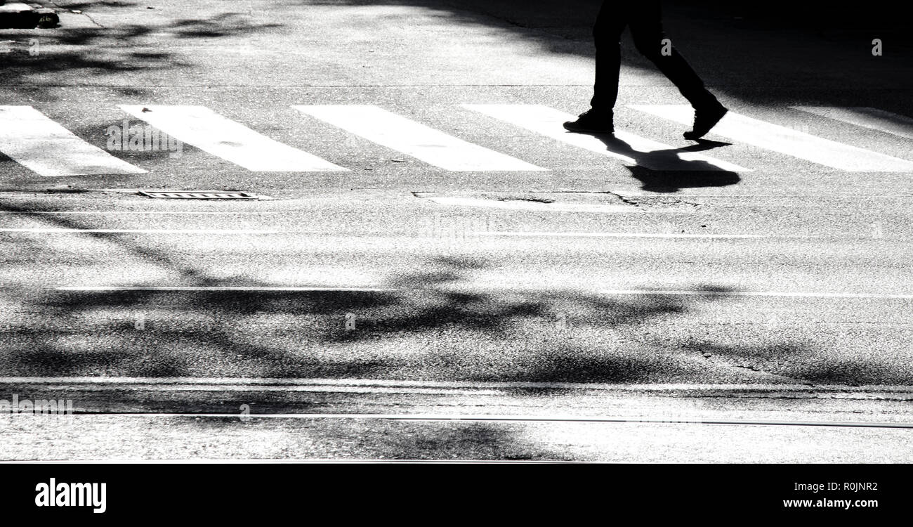 Sfocata ombra silhouette di un attraversamento pedonale via della città, in bianco e nero Foto Stock