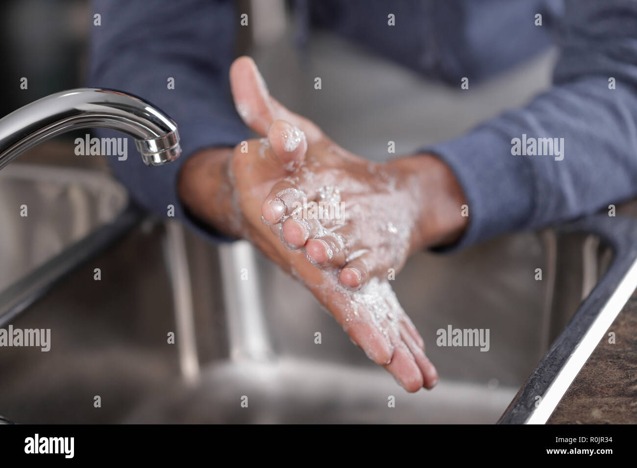 Lavarsi le mani con acqua e sapone al rubinetto, concetto di igiene Foto Stock