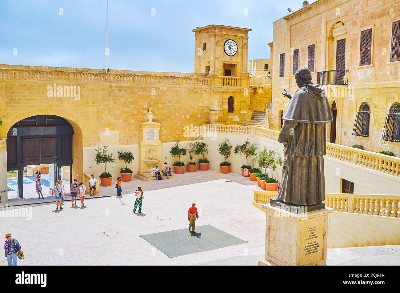 VICTORIA, Malta - 15 giugno 2018: la statua di Giovanni Paolo II, di fronte alla piazza della cattedrale di Cittadella (Rabat fortezza) con una vista sul terrapieno e orologio t Foto Stock