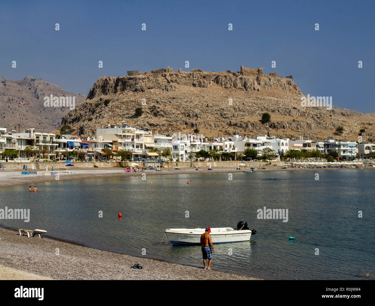 Il piccolo villaggio di pescatori e rifugio turistico di Charaki, Rodi, Grecia, con la sua spiaggia di ghiaia e di bassi edifici imbiancati. Foto Stock