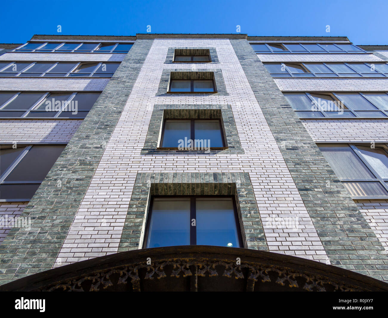 Frammento della facciata di un edificio moderno a cinque piani di mattoni di edificio di appartamenti Foto Stock