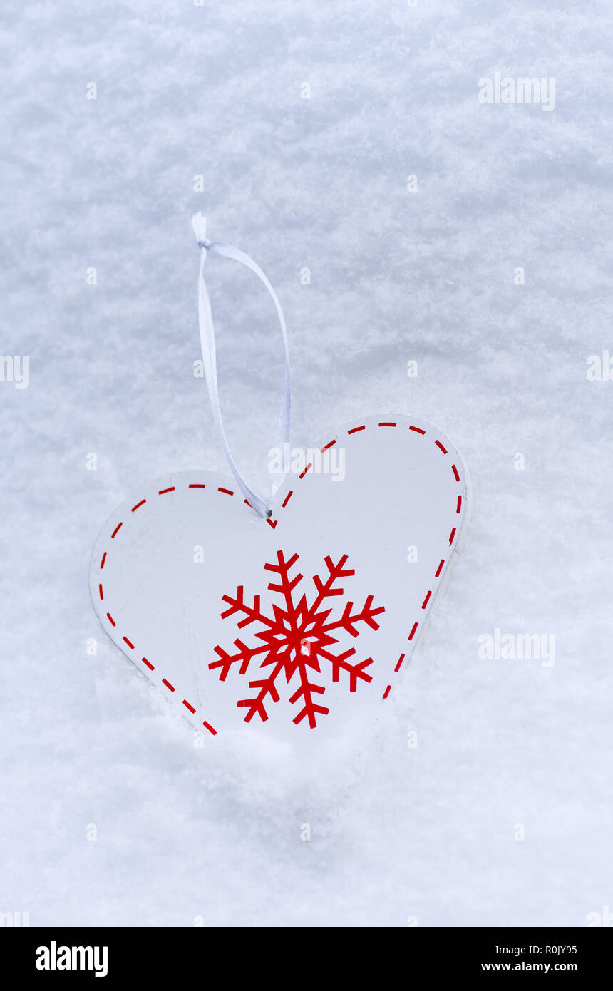 Decorazioni in legno a forma di cuore. Decorazione di Natale a forma di cuore nella neve. Foto Stock