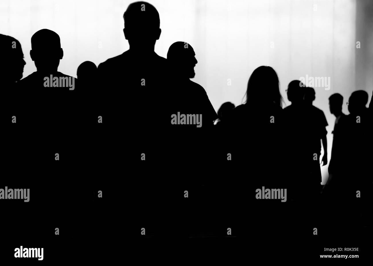Sfocata silhouette della folla di giovani a piedi di notte in bianco e nero Foto Stock