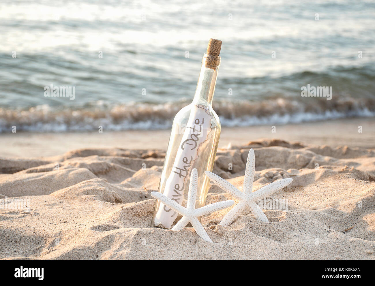 Starfish Bianco matura in spiaggia di sabbia con salvare la data del messaggio in bottiglia Foto Stock