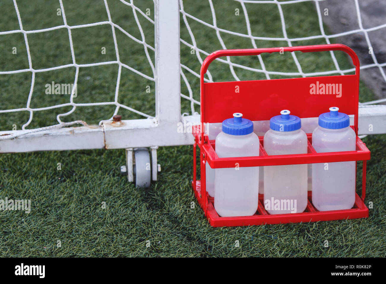 Sport bottiglie di acqua fresca bevanda energetica su di un campo da calcio in erba Foto Stock