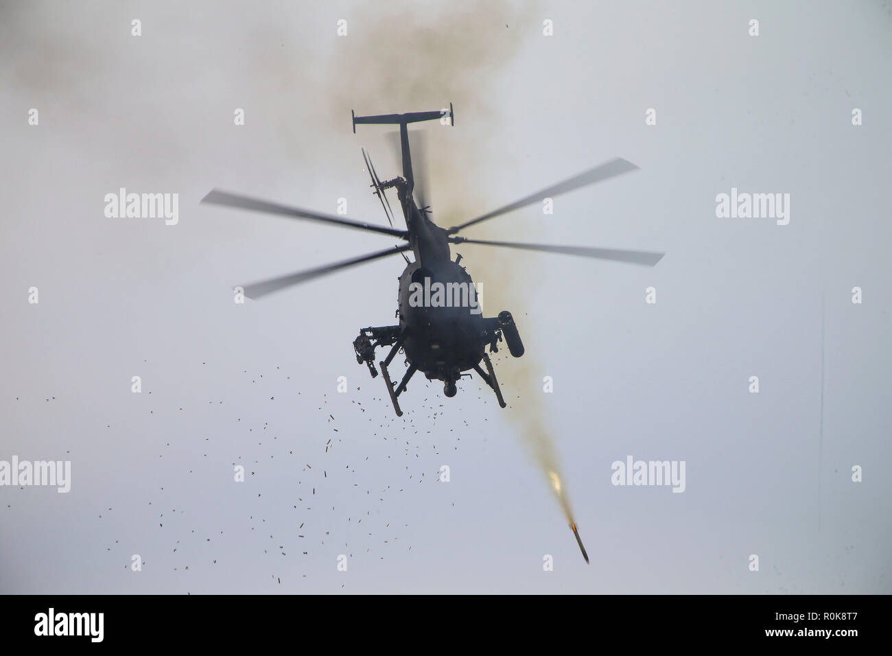 Un U.S. Esercito AH-6 uccello piccolo elicottero sparare razzi al bersaglio. Foto Stock