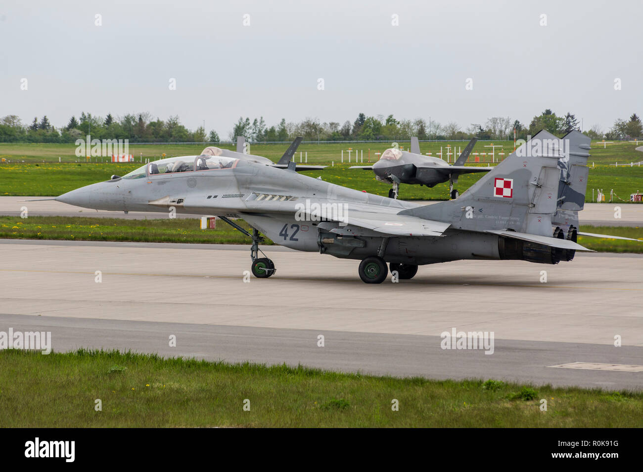 Polish Air Force MiG-29UB taxi passato un F-35 velivoli. Foto Stock