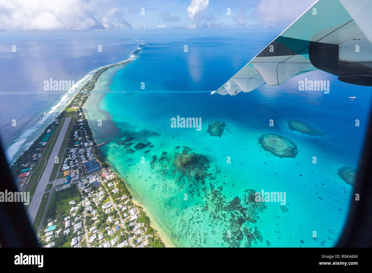 Tuvalu, Polinesia sotto l'ala di un aeroplano. Vista aerea di Funafuti Atoll e la pista di atterraggio per aerei dell aeroporto internazionale di Vaiaku. Nazione insulare. Foto Stock