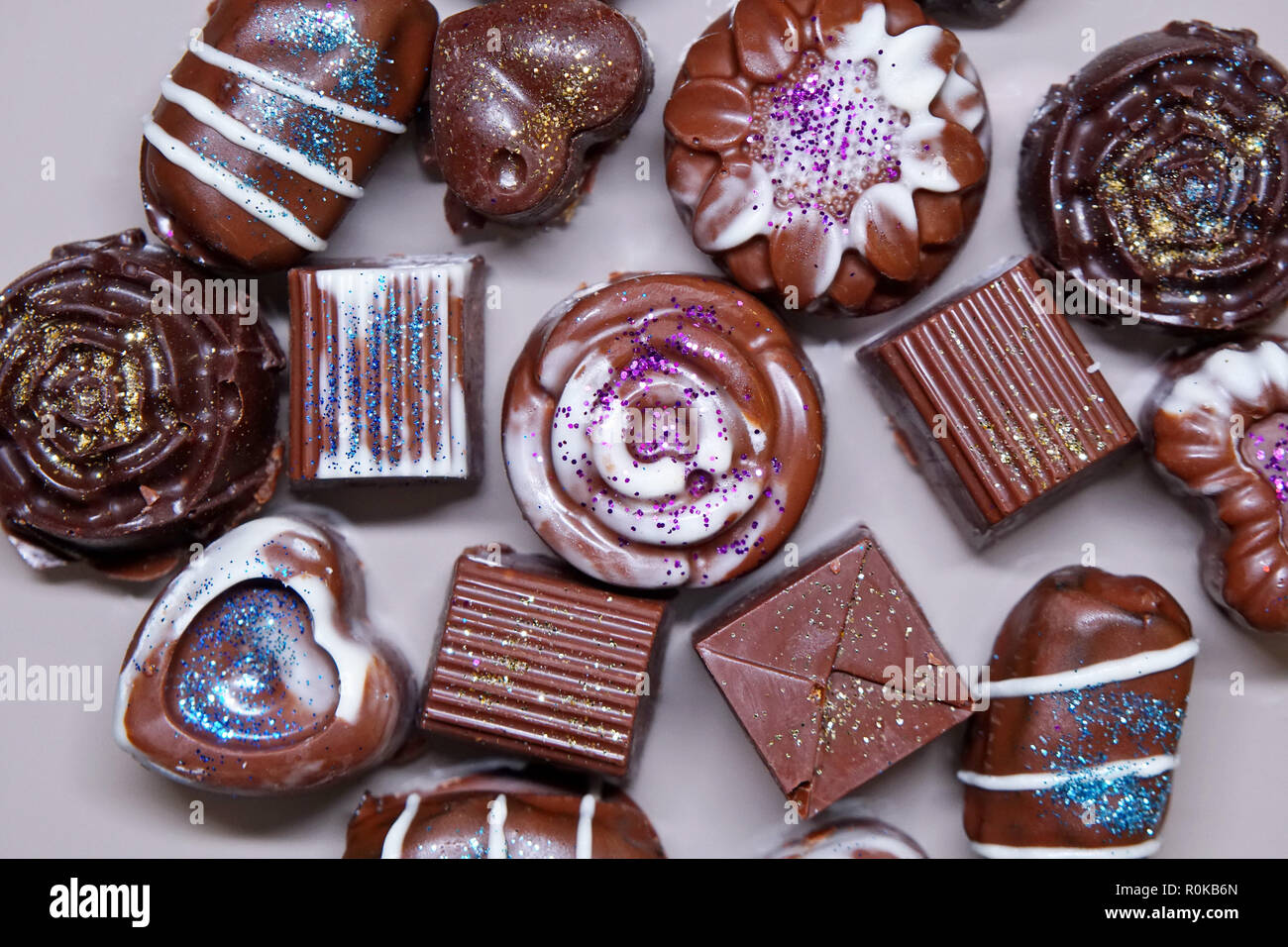 Close up di diverse forme di cioccolatini deliziosi dolci. Smalto lucido e  decorazioni di cioccolato Foto stock - Alamy