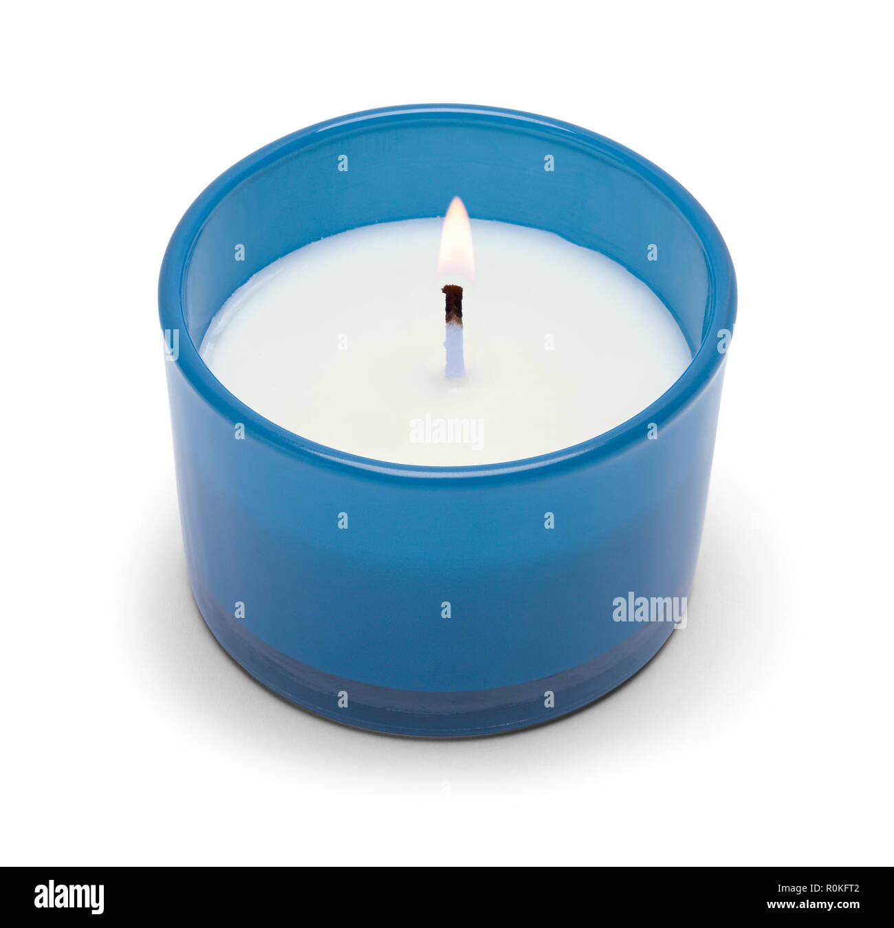 Piccola candela accesa in vetro blu isolato su uno sfondo bianco. Foto Stock