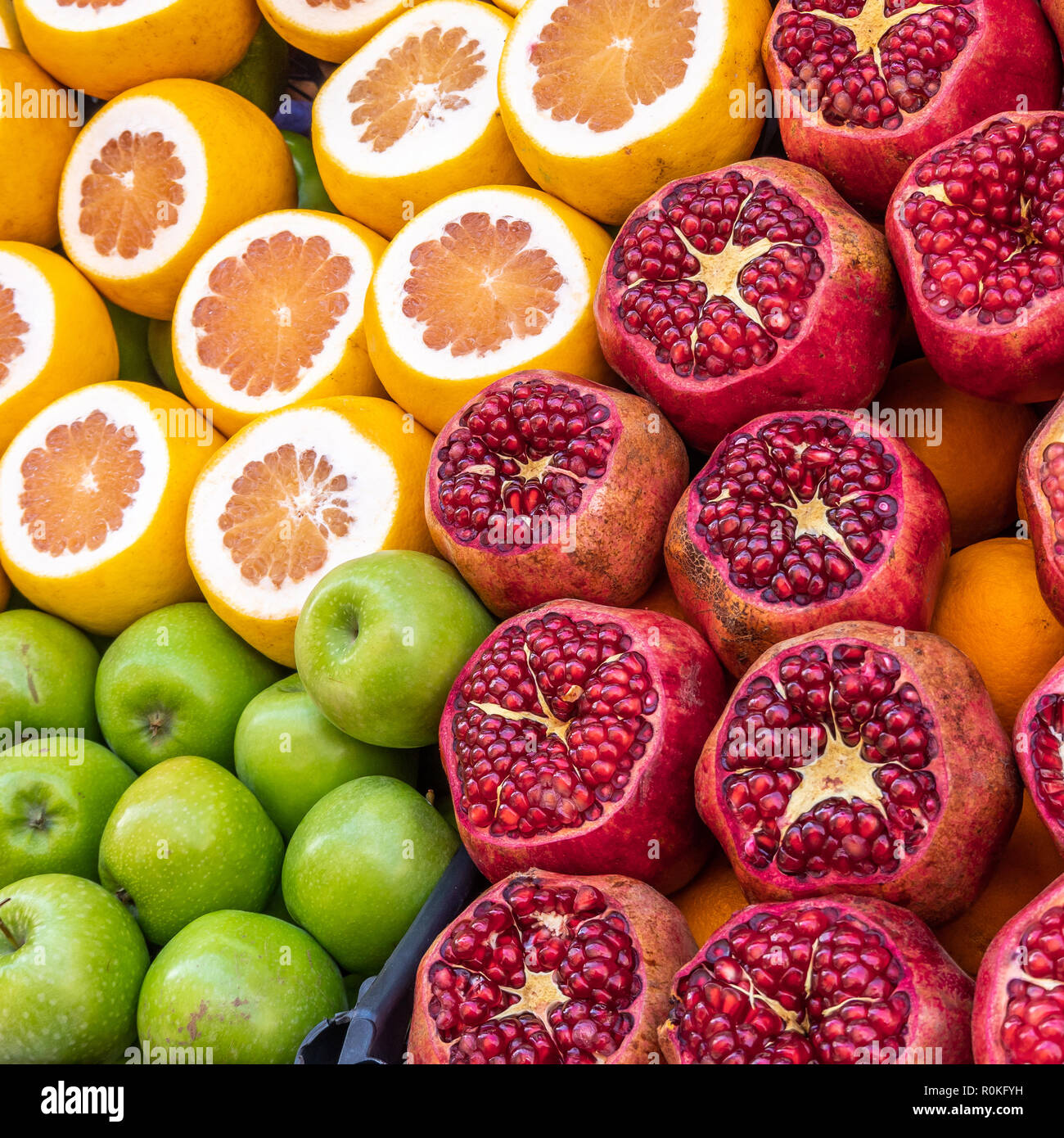 Stand di vendita per succhi di mele, arance e melograni con frutta a fette Foto Stock