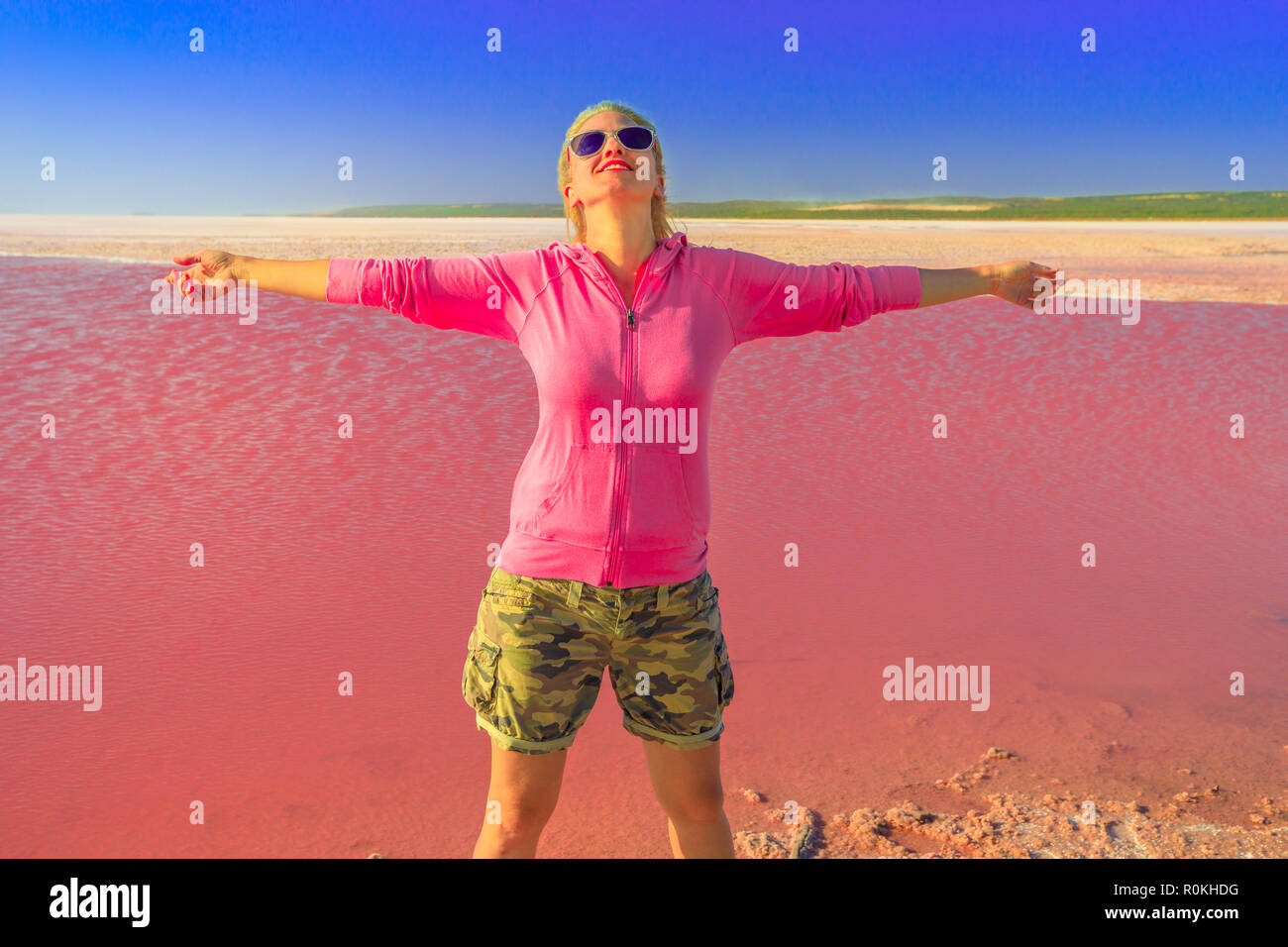 Spensierata donna turistica con le braccia aperte al Lago Rosa nel porto di Gregorio, Western Australia. Bionda giovani caucasici backpacker in laguna Hutt, Australia. Su Foto Stock