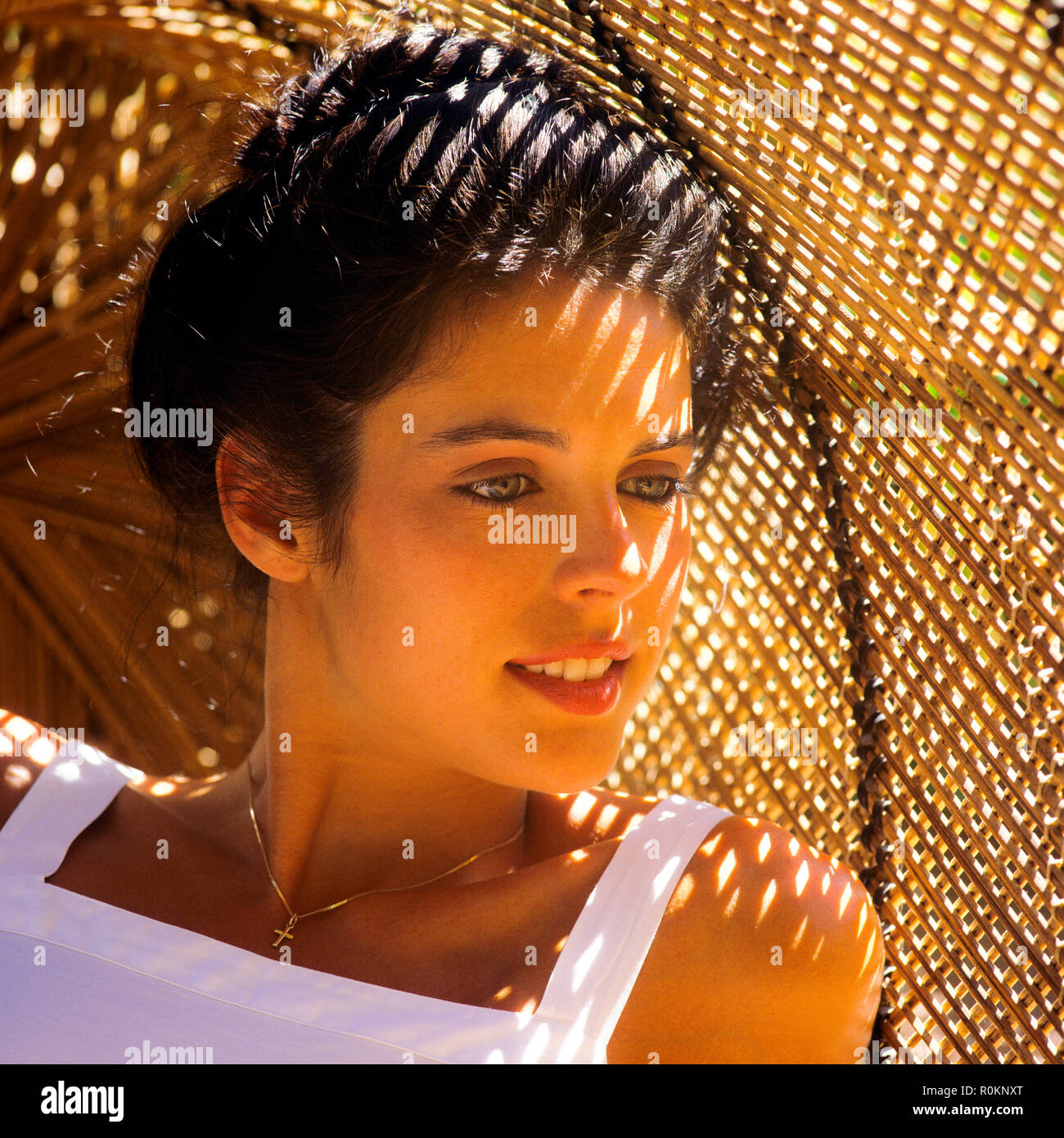 Giovane donna ritratto, guardando dal lato, sullo sfondo di vimini, Guadalupa, French West Indies, Foto Stock