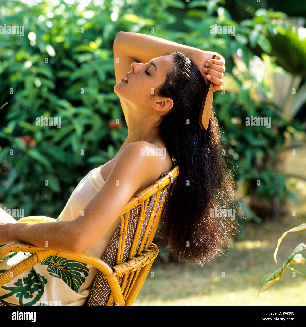 Giovane donna spazzolare i capelli, giardino tropicale, Guadalupa, French West Indies, Foto Stock