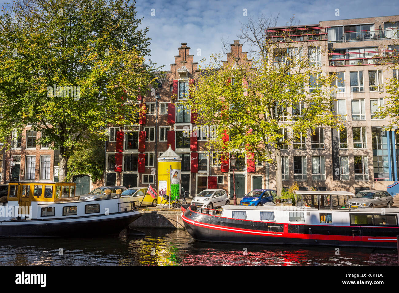 Architettura di Amsterdam, barche in canal ed edifici in autunno Foto Stock