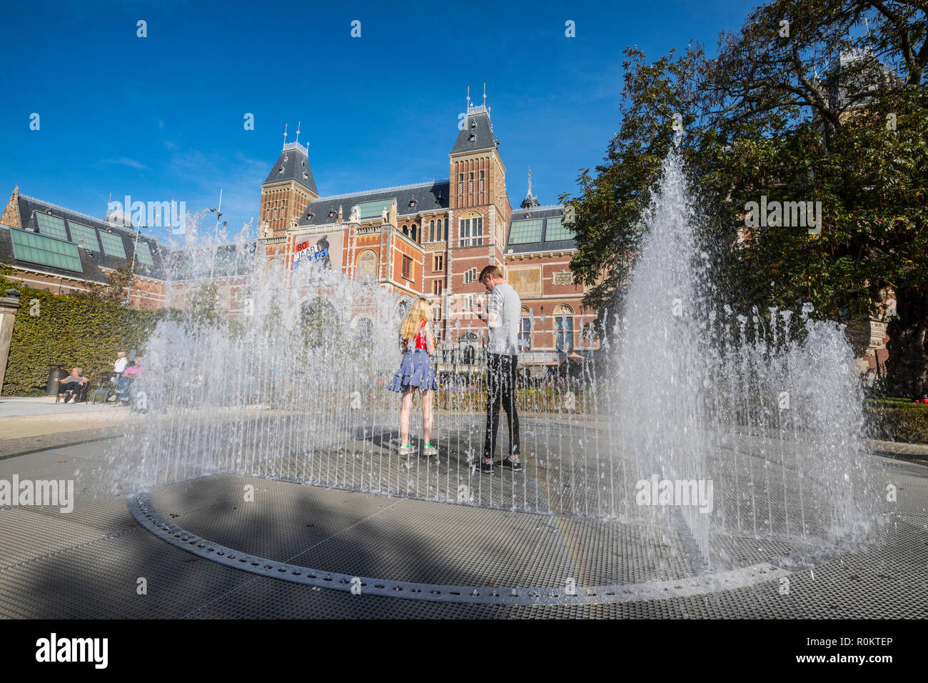 Rijksmuseum Amsterdam, coppia giovane in piedi nel centro della fontana di acqua Foto Stock
