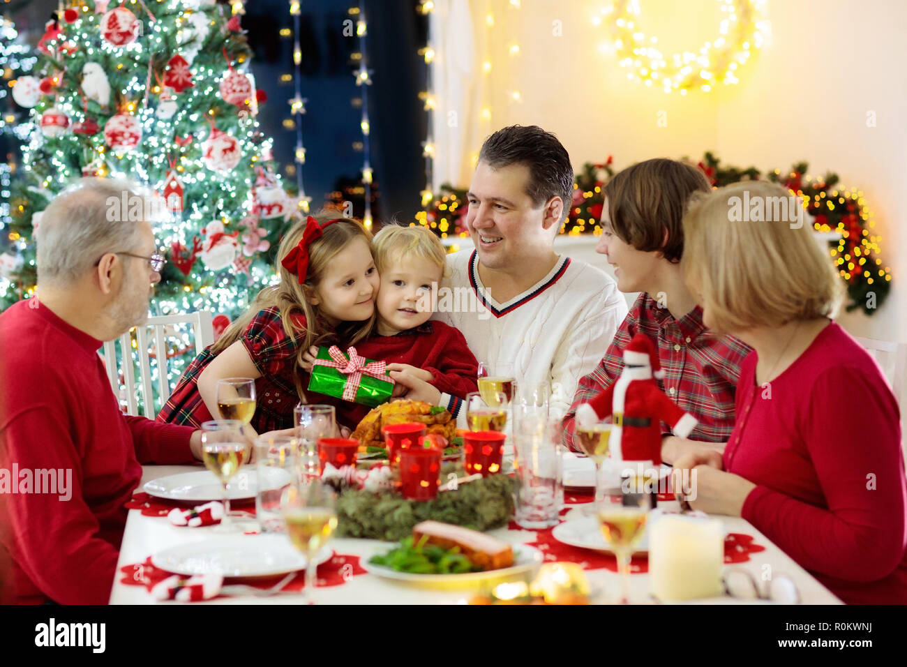 Pasti Di Natale.Famiglia Con Bambini A Mangiare La Cena Di Natale Al Camino E Decorate Albero Di Natale