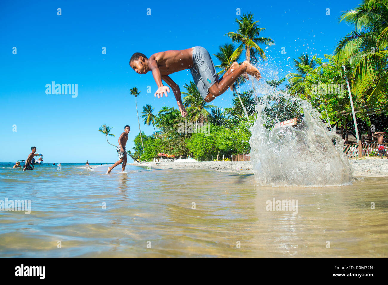 CAIRU, Brasile - circa marzo, 2018: i giovani brasiliani splash in acque poco profonde di un turista non sviluppate beach. Foto Stock