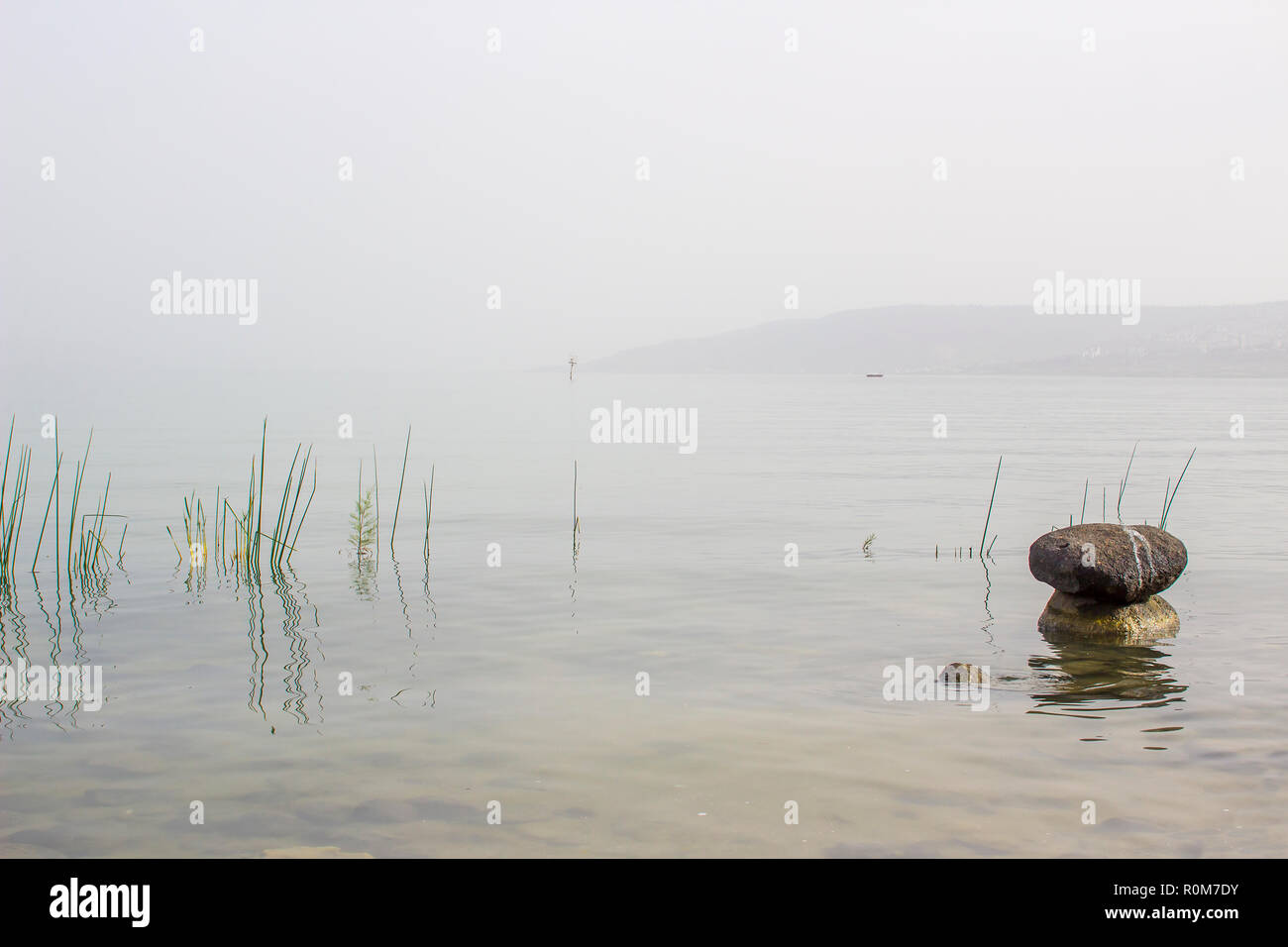 3 maggio 2018 massi accatastati insieme in calma piatta i fondali del Mare di Galilea Israele Israele in un caldo pomeriggio nebuloso Foto Stock