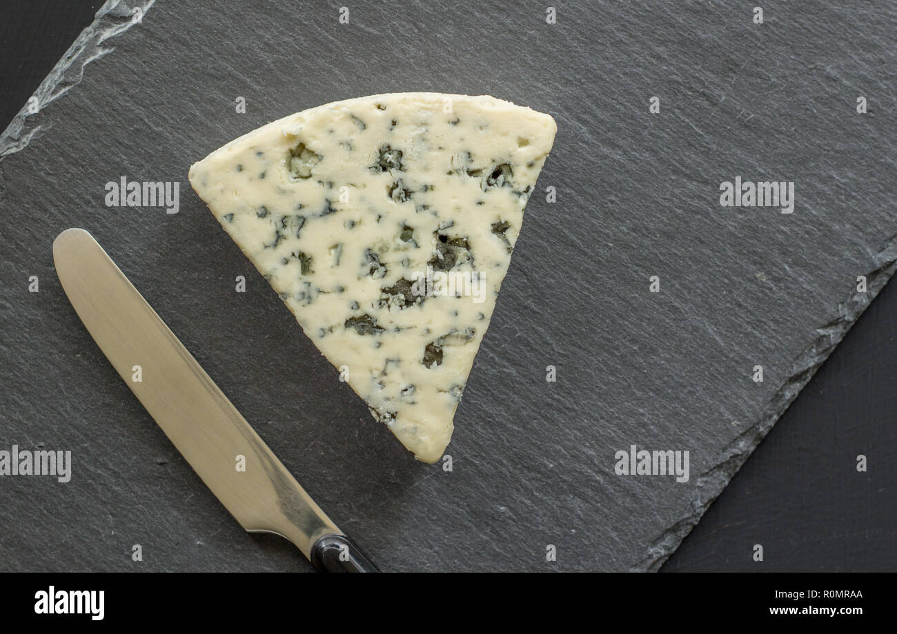 Formaggio blu isolati su nero ardesia board - Roquefort formaggio tipo sfondo vista superiore close up foto Foto Stock