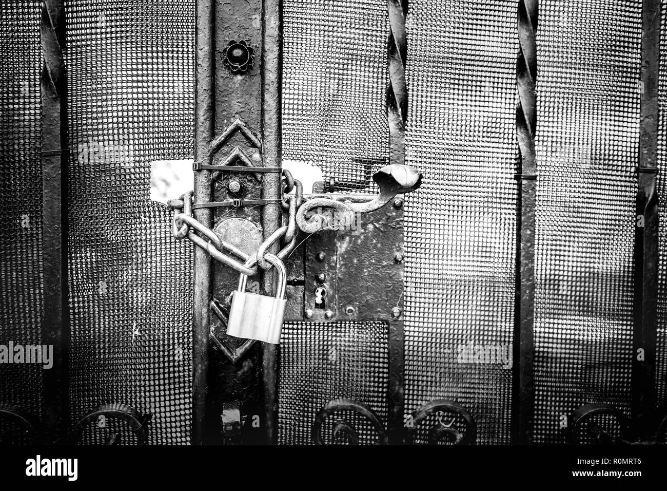 Vecchio rustico lucchetto in ottone a vecchio legno marrone scuro porta.Vintage e tono drammatico con spazio per il testo sulla sinistra. Foto Stock