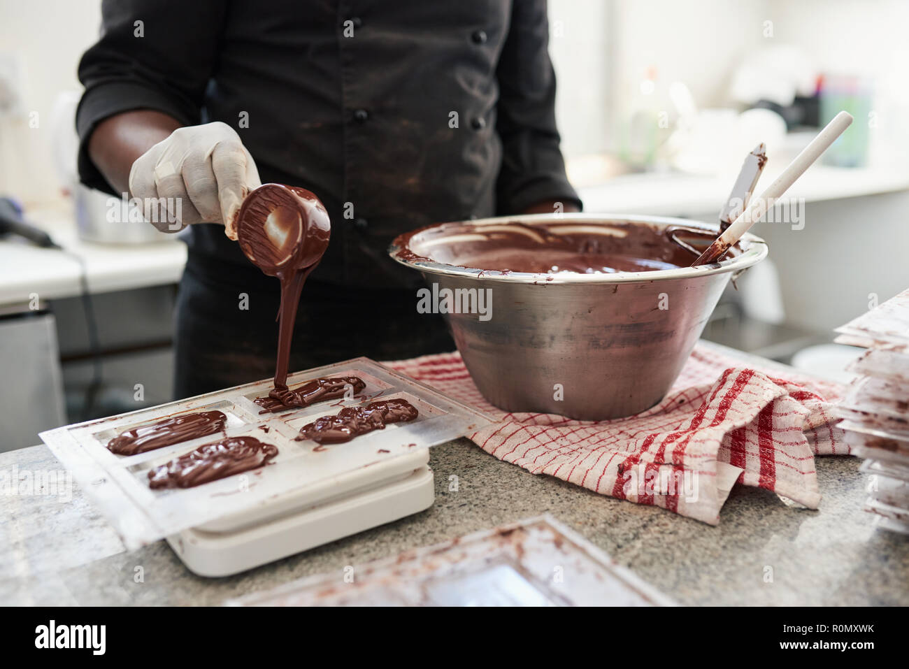 Lavoratore preparando a fare gli stampi di cioccolato fuso Foto Stock