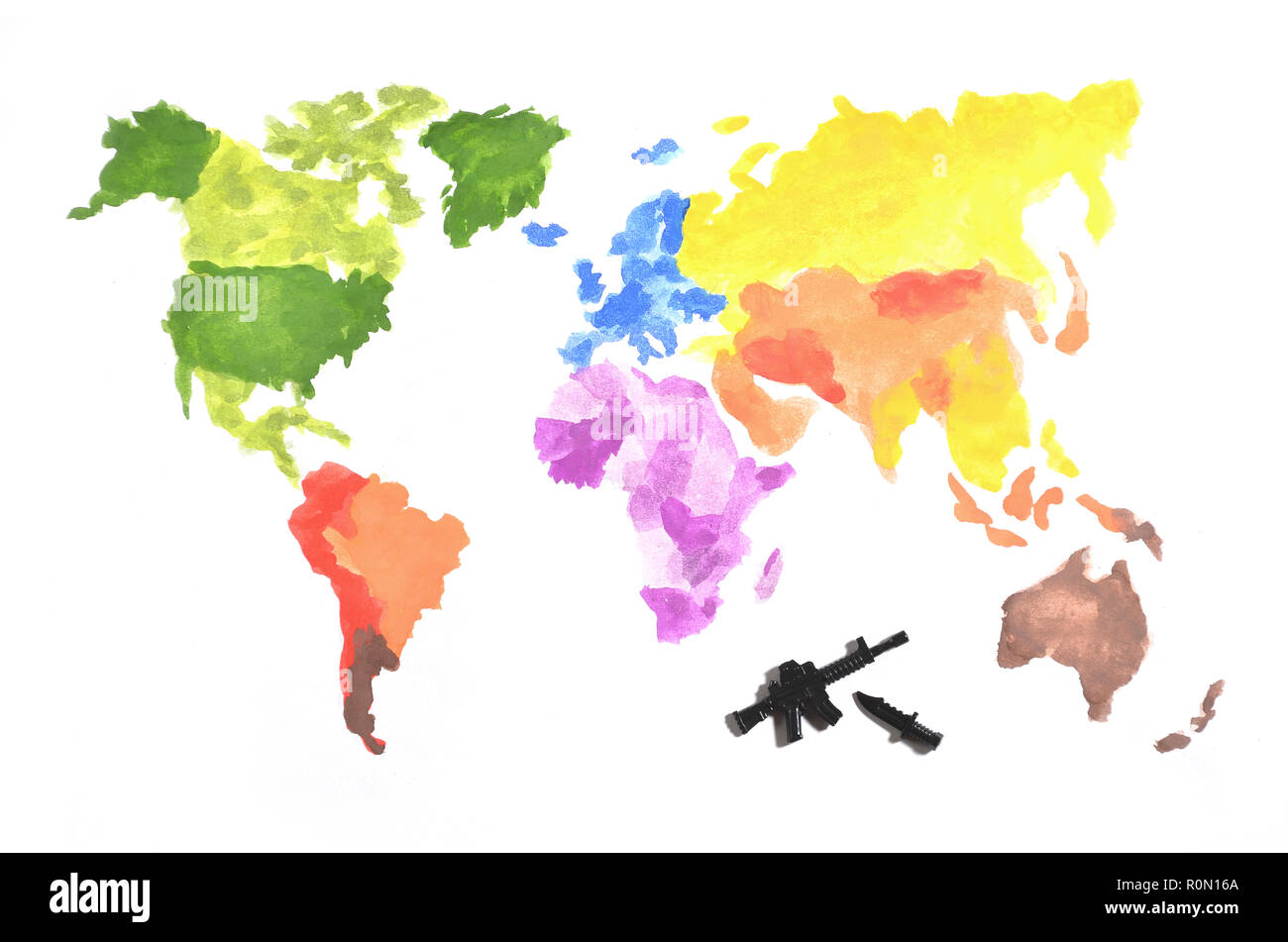 La mappa del mondo è fatta con colorate pitture ad acquerello su carta bianca con la partecipazione di un nero pistola giocattolo e un coltello. Il concetto di militari ope Foto Stock