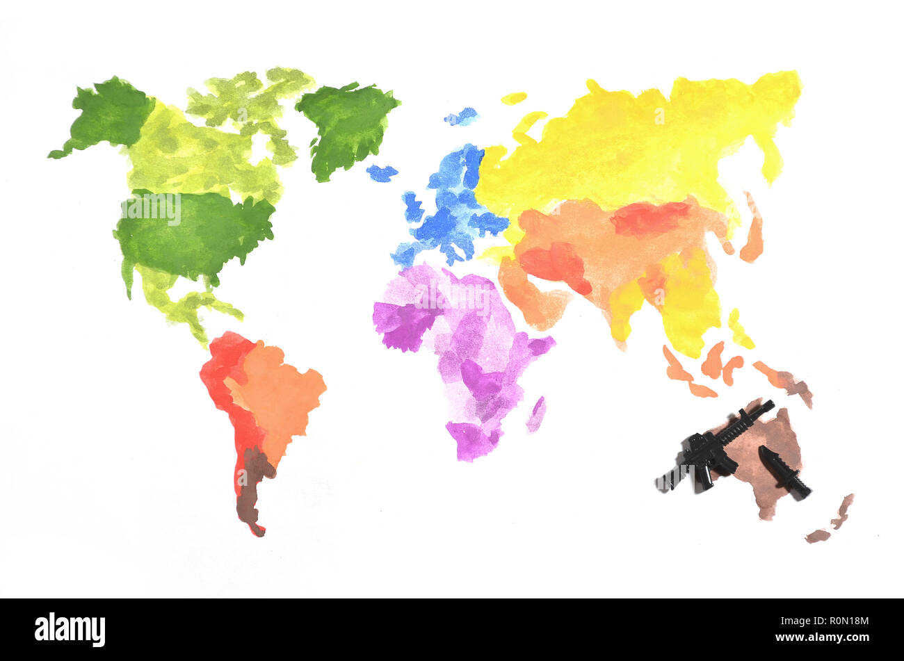 La mappa del mondo è fatta con colorate pitture ad acquerello su carta bianca con la partecipazione di un nero pistola giocattolo e un coltello. Il concetto di militari ope Foto Stock