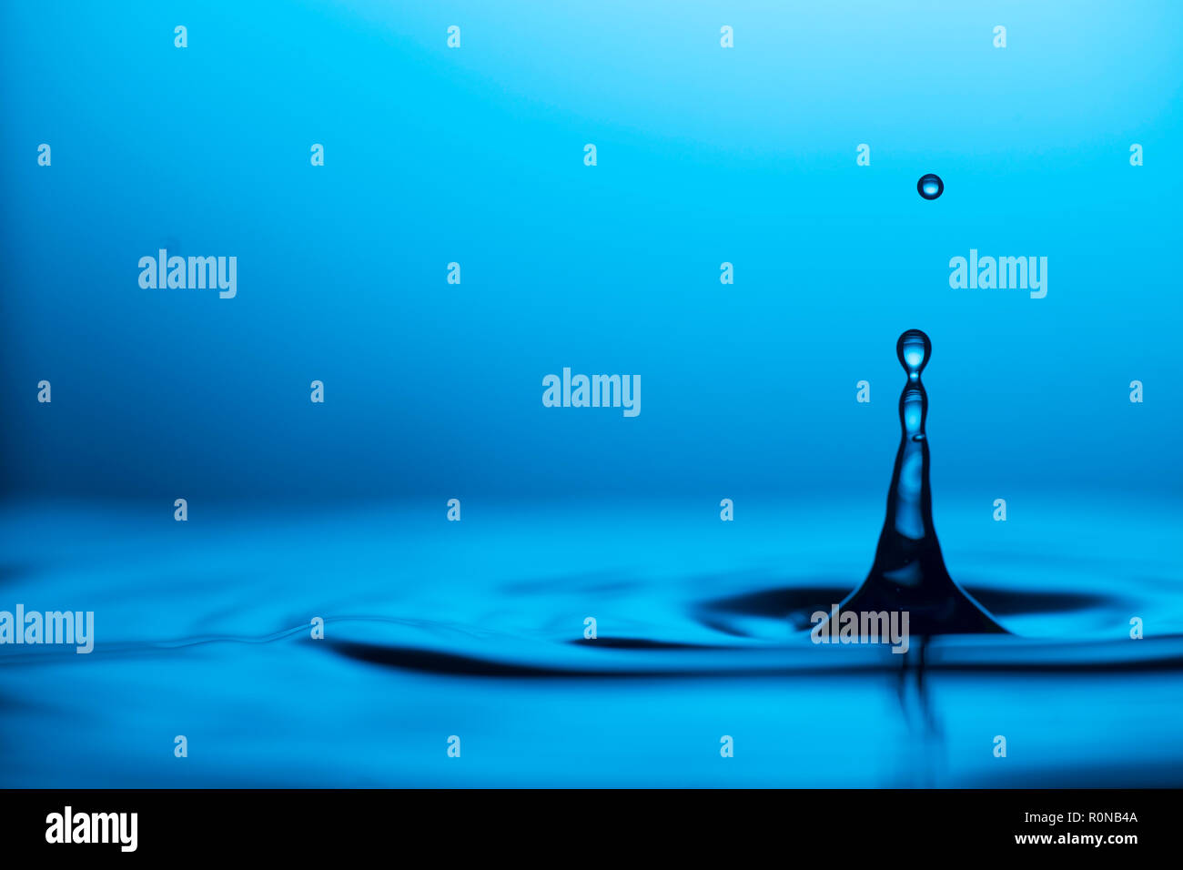 Slow motion fotografia di gocciolamento di acqua in una pozza d'acqua. Utilizzando alta velocità flash per catturare la bellezza della goccia. Foto Stock