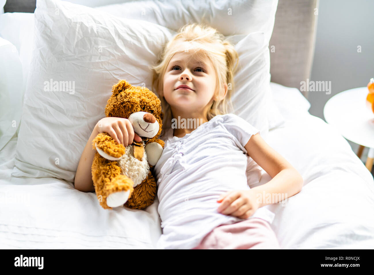 Un allegro bambina nel letto relax Foto Stock