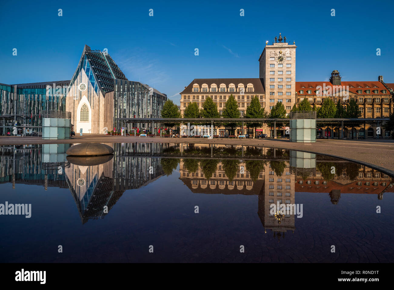 Augustusplatz Leipzig im Morgenlicht bei blauem Himmel, Spiegelung im Brunnen. Leipzig, Germania Foto Stock