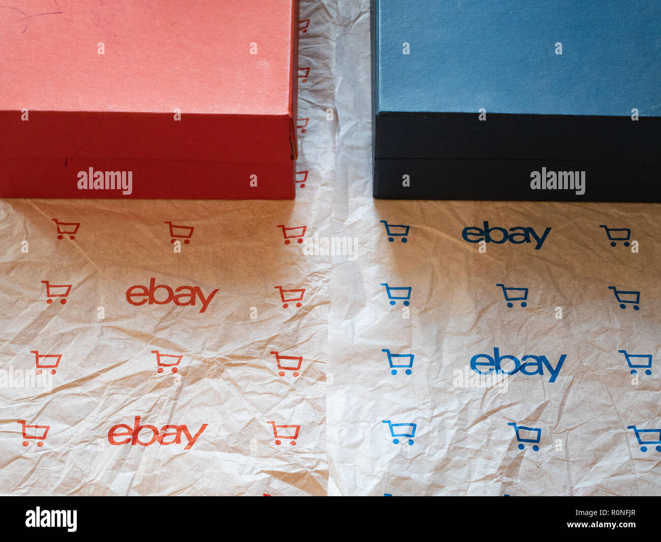 Kiev, Ucraina - 26 giugno 2018: il rosso e il blu confezioni regalo con branded Ebay carta di avvolgimento con il logo ebay e icona del carrello Foto Stock