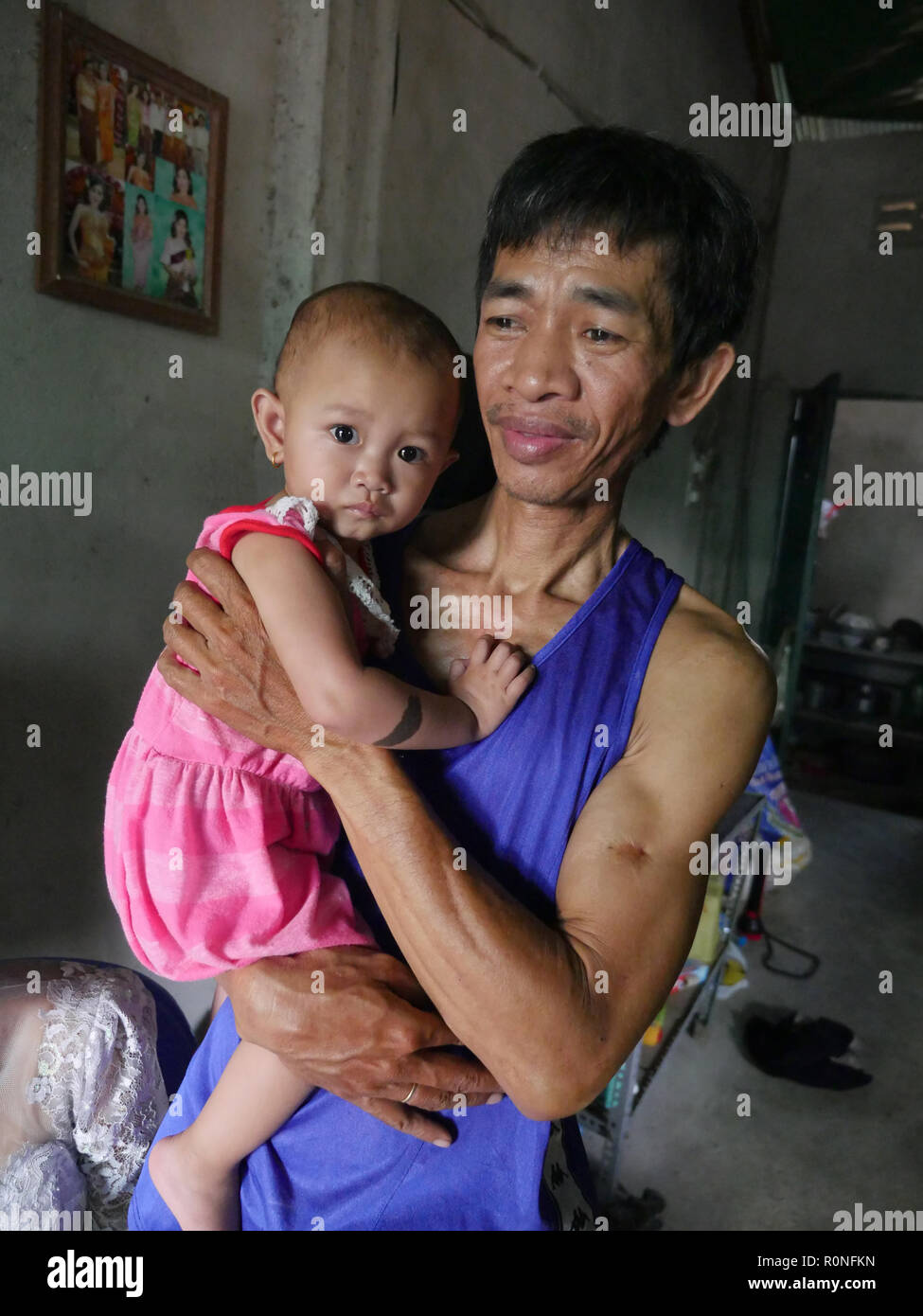 Il 'cricket lady' e famiglia, Trapeang Anchang, vicino a Phnom Penh. Beneficiari dei germogli di speranza (Maryknoll) sostentamento programma di borse di studio. La madre, Leap Chanthon (39) in soggetti HIV+ e vive una vita sana con il suo nuovo husbnad Koy Monry (HIV-) e loro HIV- bimba. Leap Chanthon hanno ricevuto il sussidio alla razza dei grilli che sono una prelibatezza comune in Cambogia quando fritte con aglio e peperoncino. I ritratti di famiglia. Foto Stock
