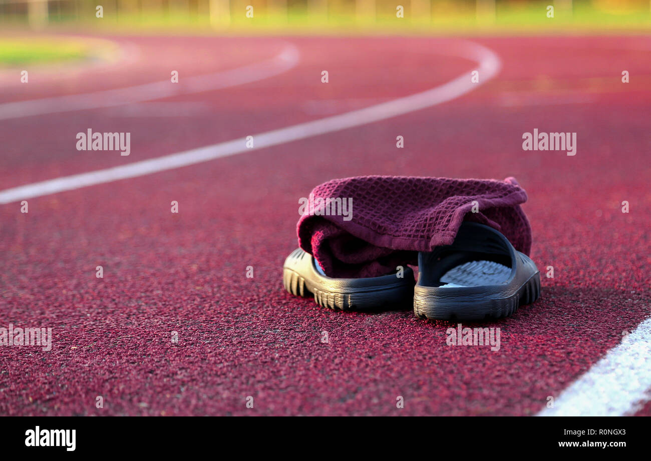 Scarpe e altri elementi sulla pista di atletica leggera a pomeriggio Foto Stock