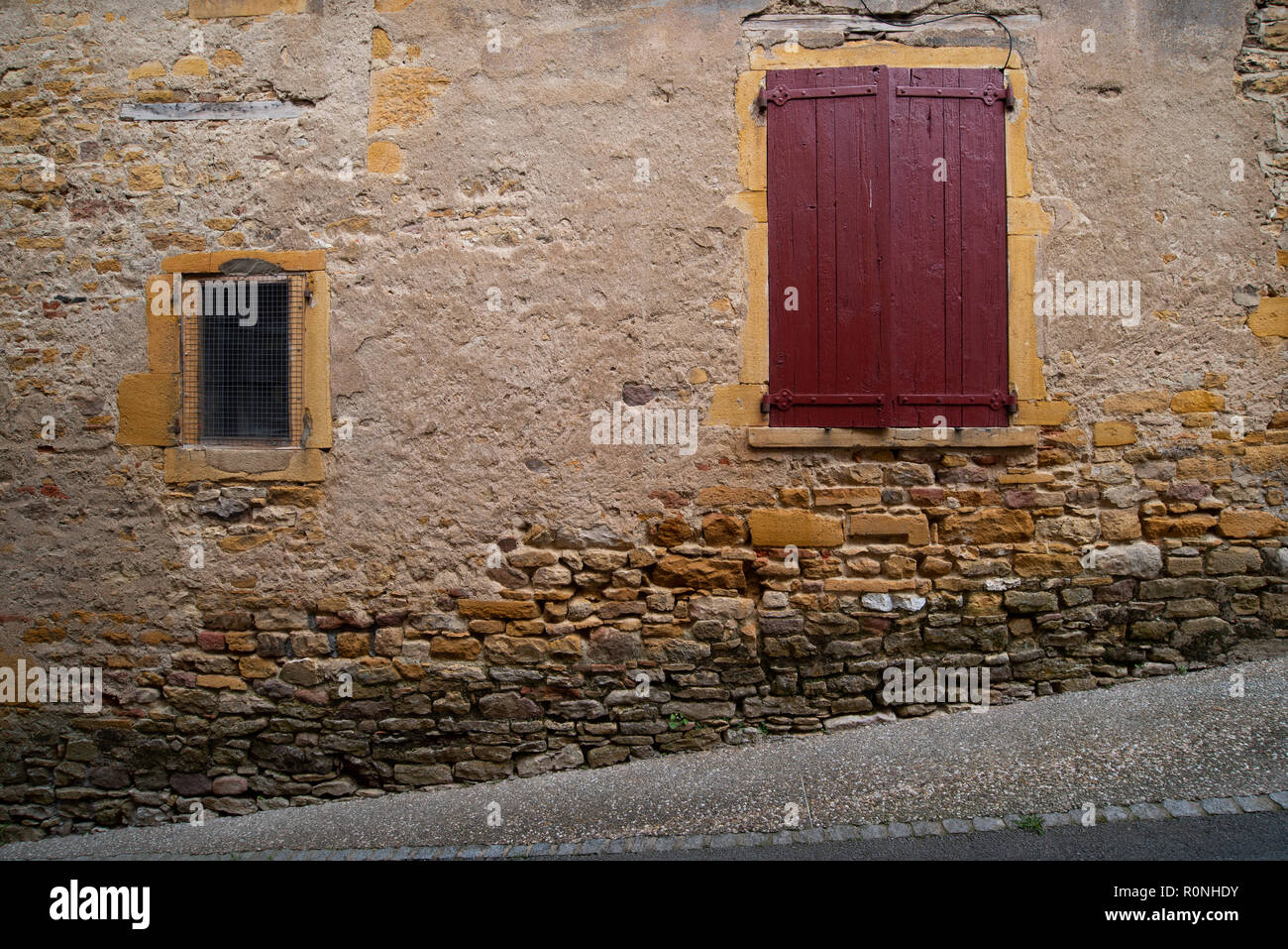 Dettaglio di una cantina porta e finestra di piccole dimensioni lungo una strada nel pittoresco villaggio di Beaujolais di Oingt, Francia Foto Stock