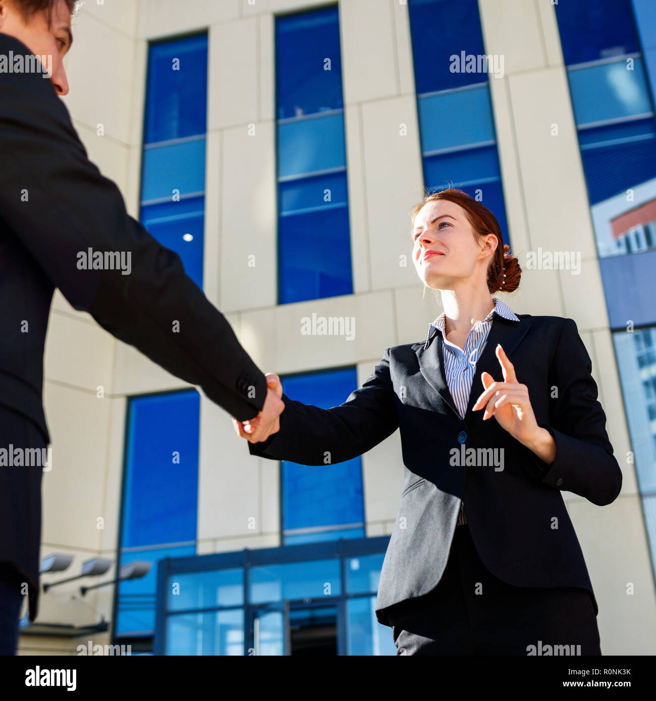 Business donna e uomo si stringono la mano all'esterno. Business il concetto di cooperazione Foto Stock