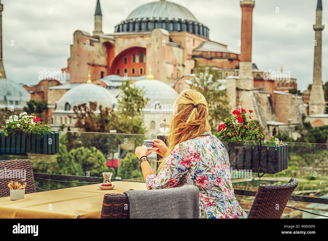 Ragazza beve caffè turco godendo la vista del Museo Hagia Sophia. Istanbul, Turchia. Foto Stock