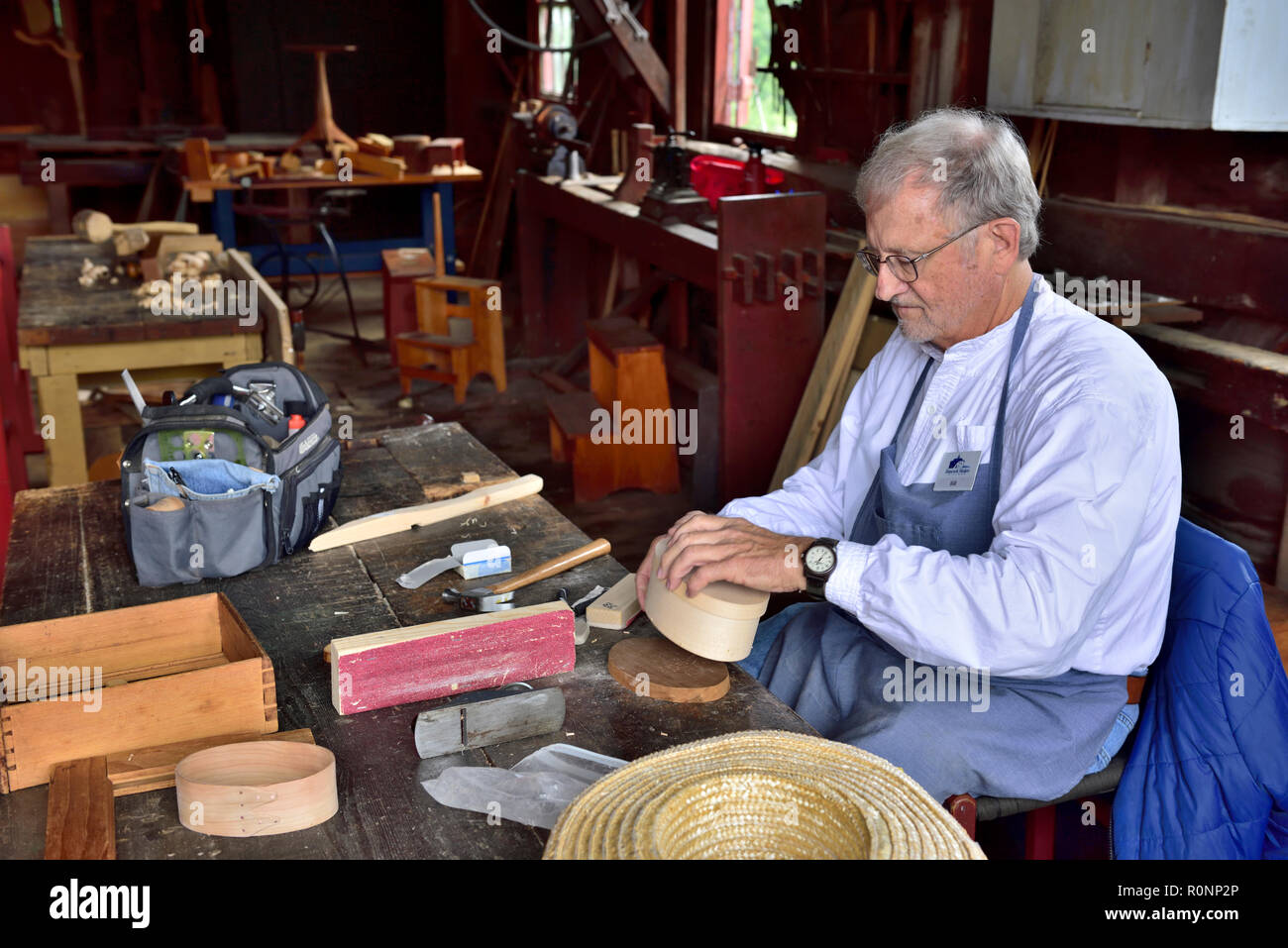 All'interno di Hancock Shaker Village falegnameria officina con un uomo che fa un tradizionale Shaker ovale scatola in legno di Pittsfield MA, Stati Uniti d'America Foto Stock
