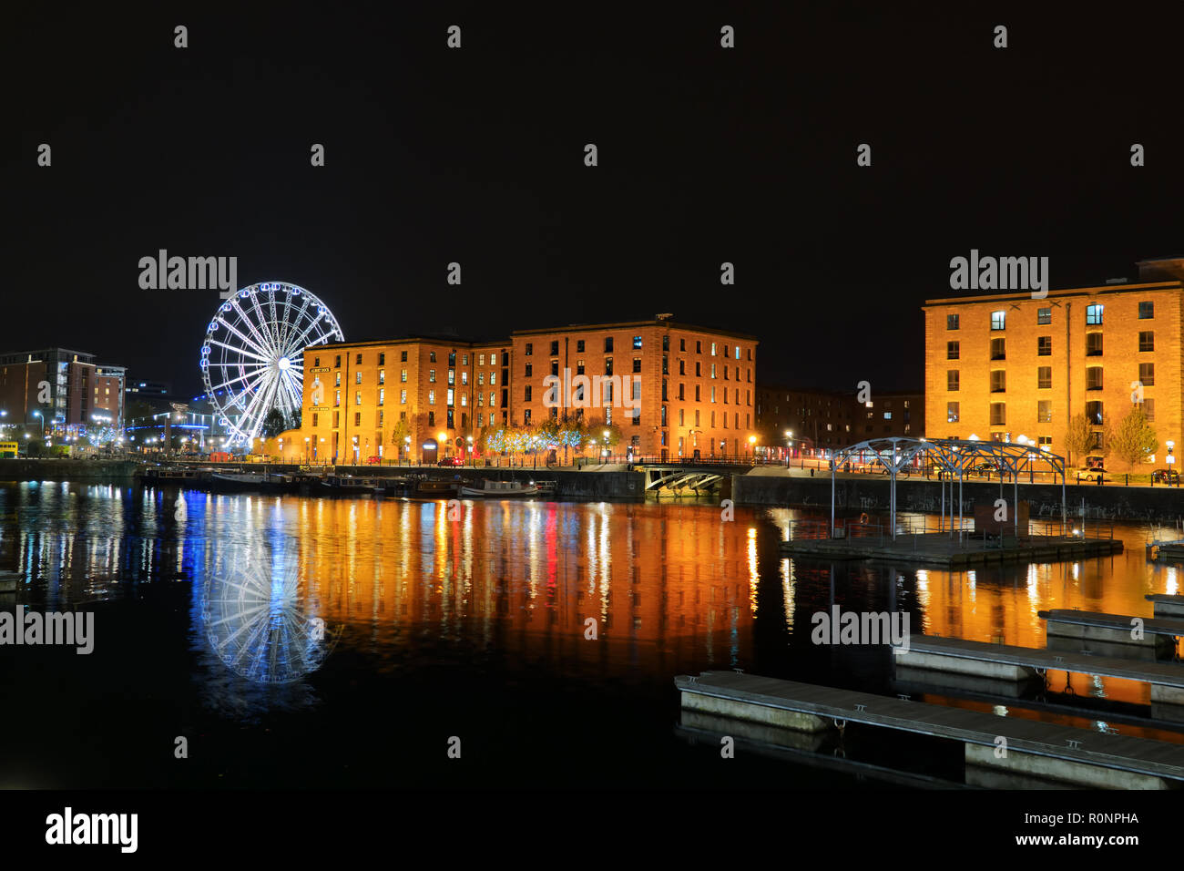 Il Royal Albert Dock Liverpool Regno Unito edifici illuminata di notte con riflessi nell'acqua dock 2018. Foto Stock