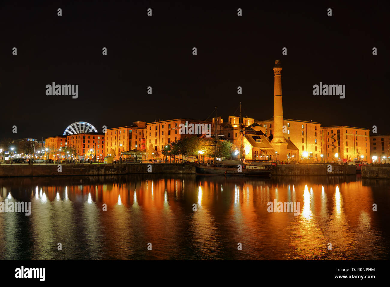 Il Royal Albert Dock Liverpool Regno Unito edifici illuminata di notte con riflessi nell'acqua dock 2018. Foto Stock