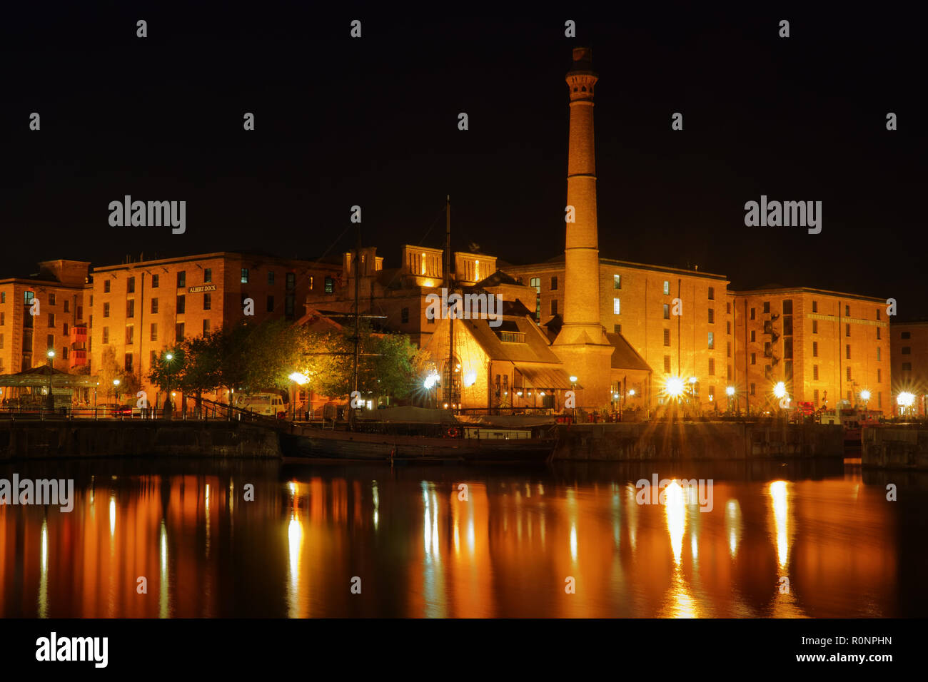 Il Royal Albert Dock Liverpool Regno Unito edifici illuminata di notte con riflessi nell'acqua dock 2018. Foto Stock
