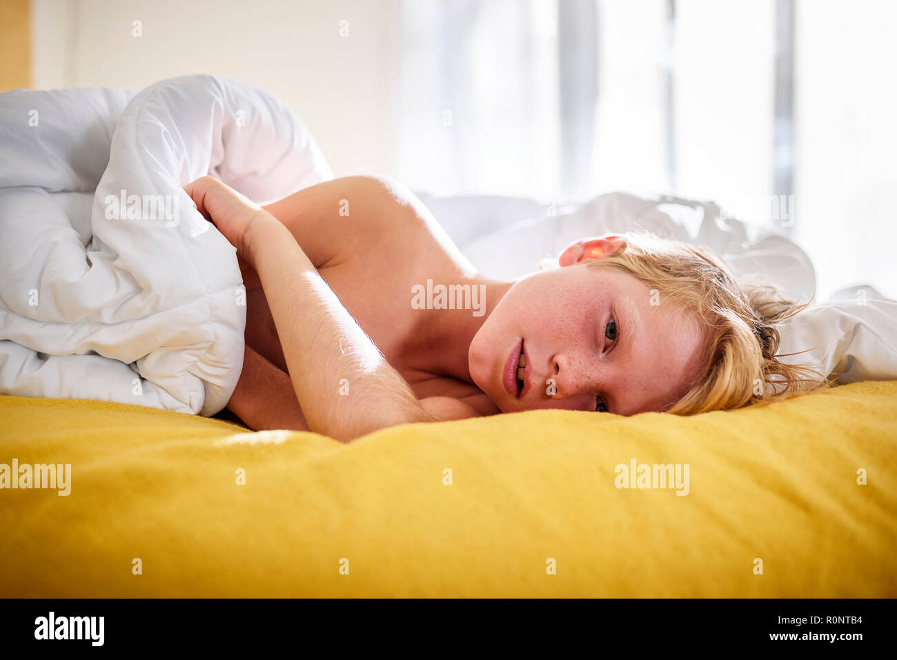 Ragazzo che giace nel letto risveglio Foto Stock