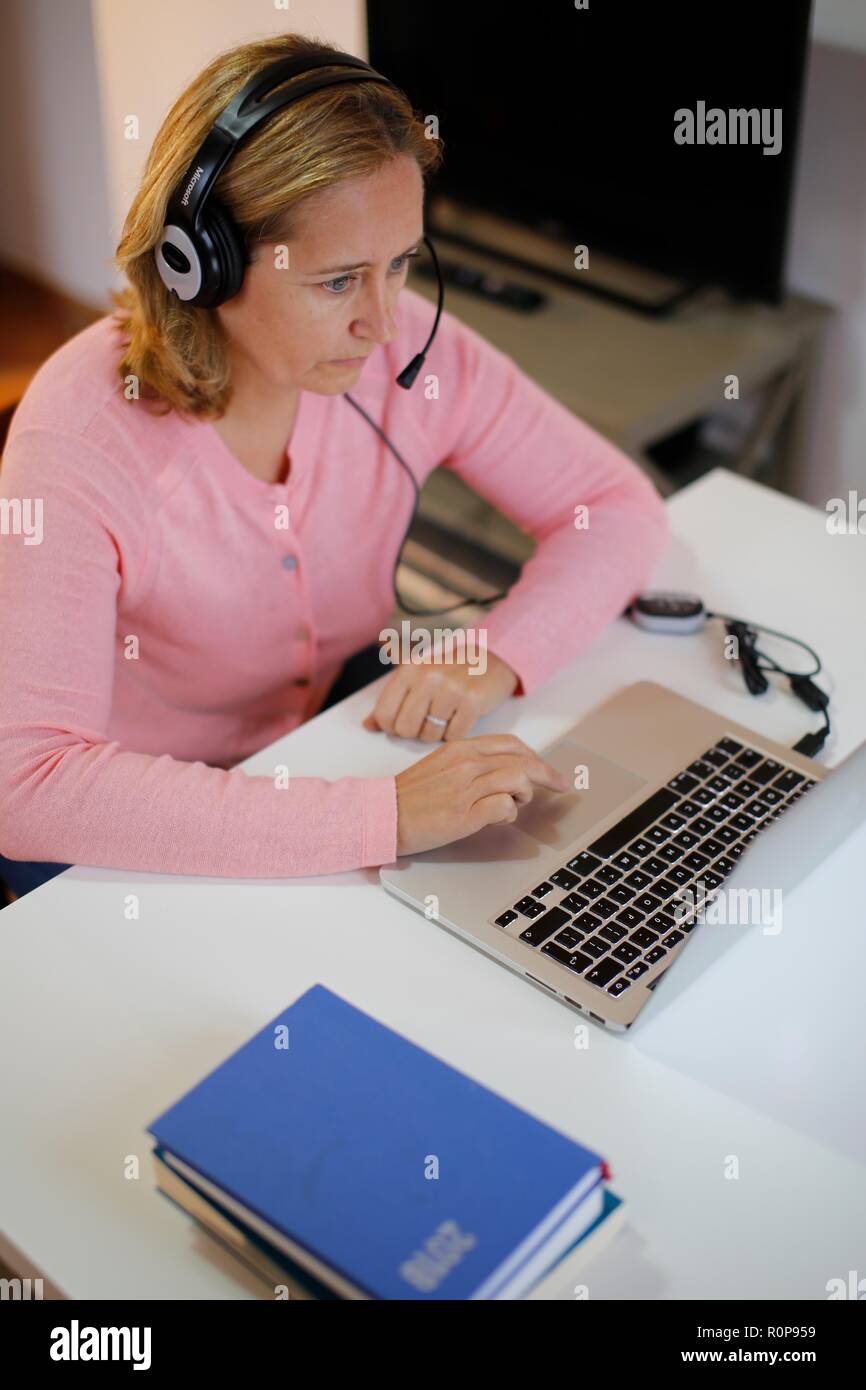 Donna che lavorano da casa su computer portatile Foto Stock