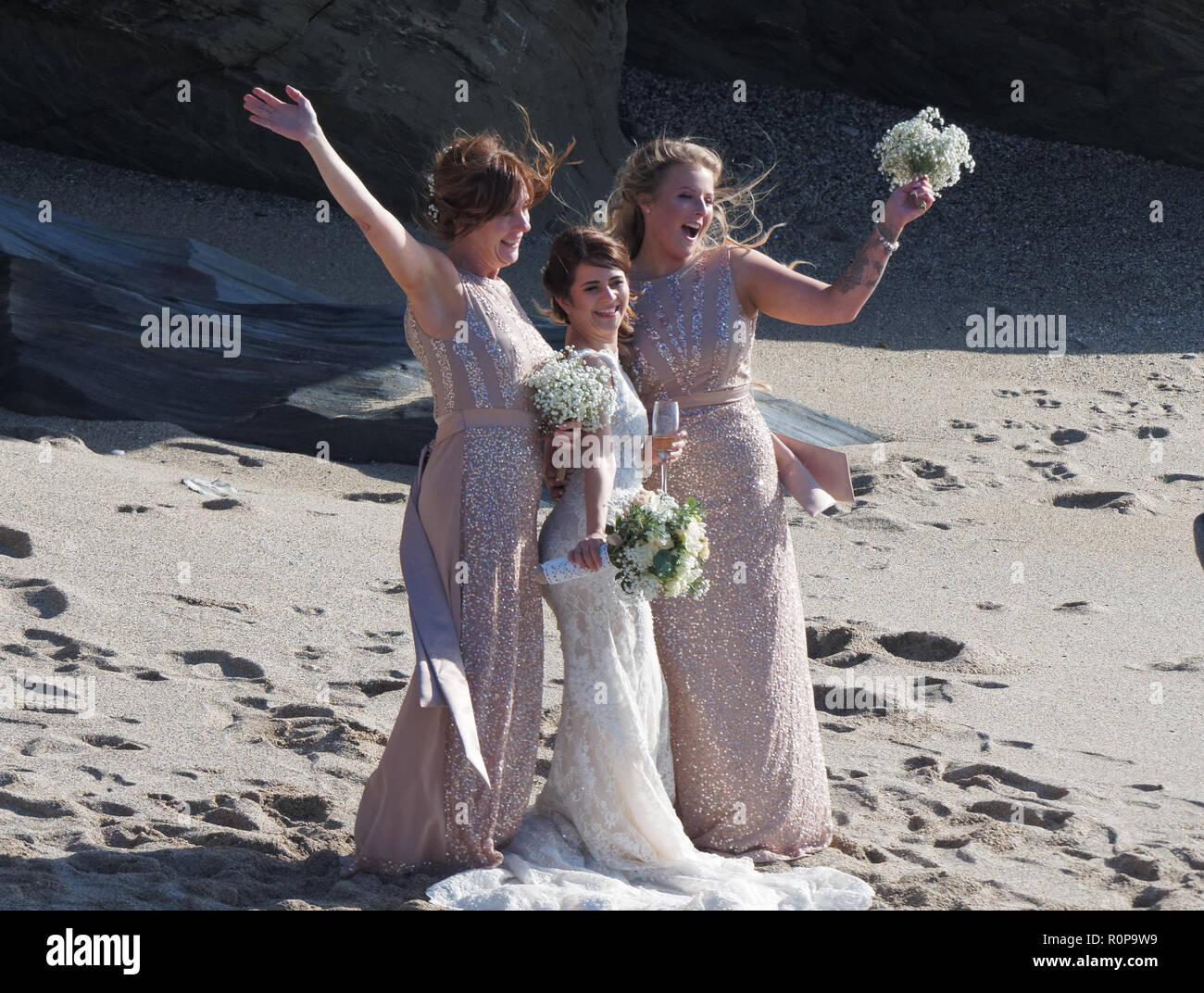 Sposa catturati da onda sulla spiaggia, Newquay, Cornwall, Regno Unito. Foto Stock