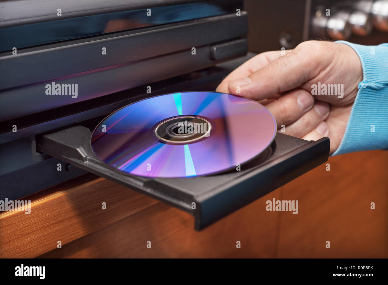 Mano azienda inserendo il DVD di video player Foto Stock